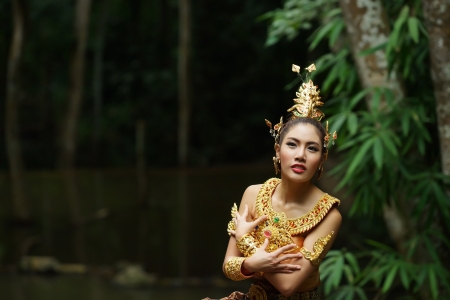 Beautiful Thai lady in Thai traditional drama dress, posing in the forest, greenery in the background, model is Thai Ethnicity.の写真素材