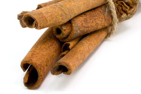 Cinnamon sticks tied by rope isolated on white background.