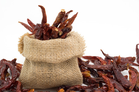 Dried chili in sack bag, isolated on white background.の写真素材