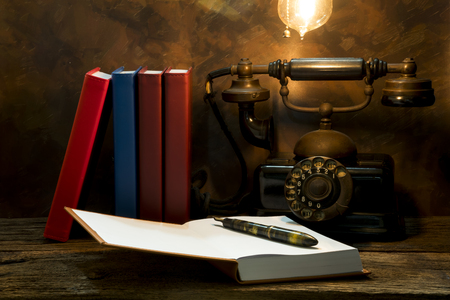 Still life of vintage telephone on table with diary book.の写真素材