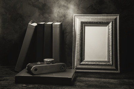 Still life of picture frame on table with vintage camera and diary book, Black and White image