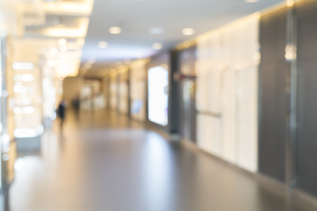 Blurred photo of corridor in modern building, background uses