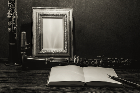 Still life of picture frame on wooden table with clarinet.の写真素材