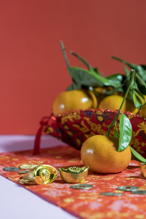 Chinese new year decorations, Orange, gold ingots, coin / Auspicious ornaments / on red background, Selected Focusの写真素材