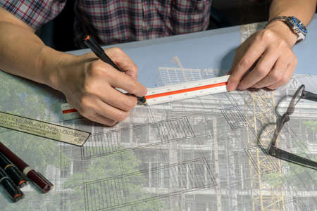 Double exposure of Architects are drawing on blueprint.の写真素材