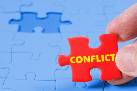 Close up of Red jigsaw puzzle with Conflict word, business solution conceptの写真素材