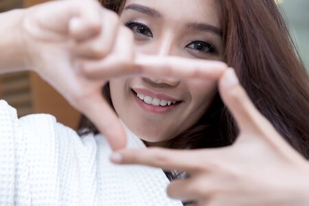 Happy young Asian Woman showing frame finger sign.の写真素材