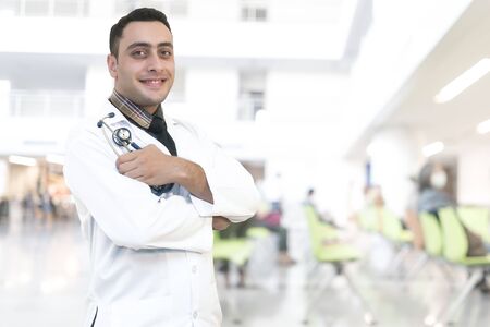 Cheerful doctor standing in a hospital, with clipping path