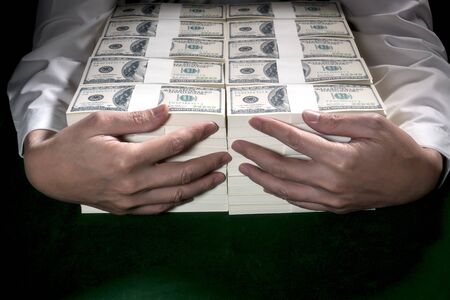Businessman embrace 1 million US dollars in his arm.の写真素材