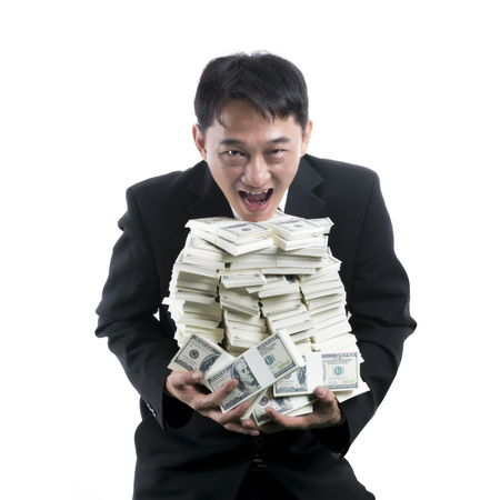Cheerful excited young businessman laughing and holding a pig pile of money on white background
の写真素材