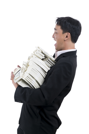  Left angle of young businessman in black suit standing and facial expression is excited, great happiness and laugh with a large amount of money in his arms on white backgroundの写真素材