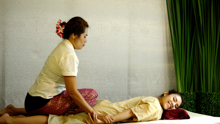The masseuse pulls the arms and bending back of client, traditional therapy for spine for pretty woman, Thai massage conceptの写真素材