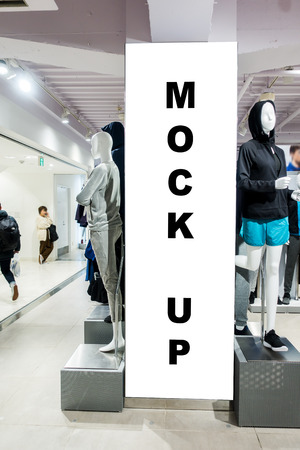 The mock up a vertical signboard at clothing store with clipping path, blank white screen for advertising or promotion の写真素材