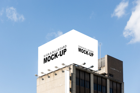 The mock up of the large billboard over the building with clipping path, blank white space for advertisement outdoors on the roof with spotlight and blue sky backgroundの写真素材