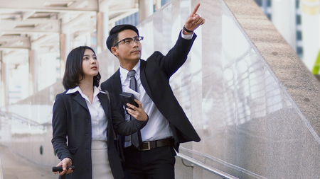 Close up at Asian young businessman has route guidance to pretty woman, He raised a finger pointing the way to herの写真素材