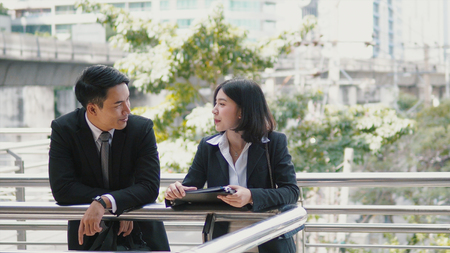 Close up Male and female Asian co-workers are talking together on the bridge,  outside the office working, co-worker conceptの写真素材