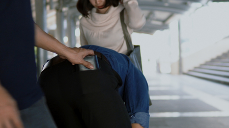 Scene of Gang stole situation to steal by pretty woman as decoy approached the young man, something dropped to floor, man help keep it up,  before a thief man came to steal  purse from jeans pocket の写真素材