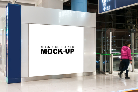 Mock up blank advertising billboard on side of show room with clipping path, empty space on white screen for information or announcement in airport area, blurred passenger on walkwayのeditorial素材