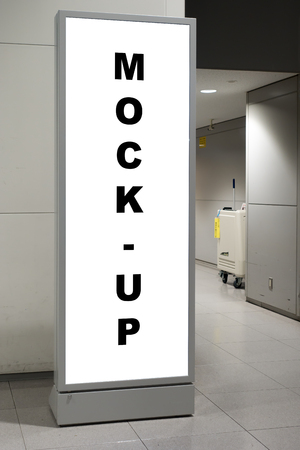 Mock up blank space on vertical advertising signboard on metal stand in airport with clipping path, copy space white screen display for indoor advertisement or information at entrance of toiletの写真素材