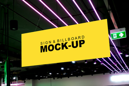 Mock up horizontal blank banner hanging from the ceiling with clipping path nearly exit signboard, Empty yellow screen for advertising or information, business marketing and advertising conceptの写真素材