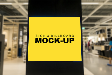 Mock up blank advertising signboard on black partition with clipping path, blurred background in shopping mall, empty space with yellow screen for advertising ,information or announcementの写真素材