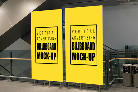 Mock up perspective two vertical blank yellow screen billboard with clipping path on metal stand place near trash can and escalator for information promotion or announcement in shopping mallの写真素材