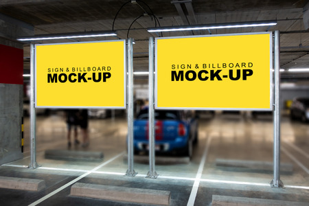 Mock up perspective two horizontal advertising billboard with clipping path on metal pole at car park building, blank yellow screen empty space for in formation, advertisement or announcementの写真素材