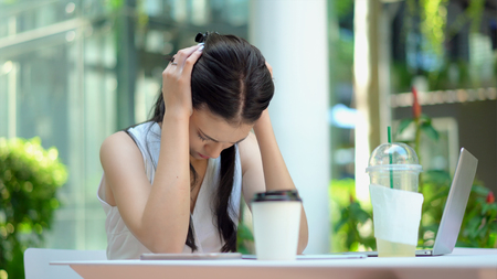 Close up the young woman sitting and used two hands to close her ears with feeling stressed and boringの写真素材