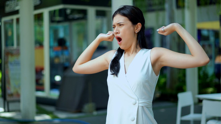 Selective focus the pretty woman standing and raised an arm stretched up yawning sleepy and copy spaceの写真素材