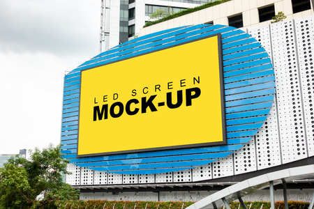 Mock up large blank yellow screen LED billboard or signboard with clipping path on the outside wall of the building or showroom, perspective with empty space for advertising informationの写真素材