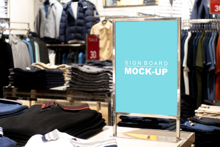 Mock up blank vertical billboard on steel stand with clipping path, perspective, blue screen empty space for insert text or advertising promotion on table near the hangers men's clothing storeの写真素材