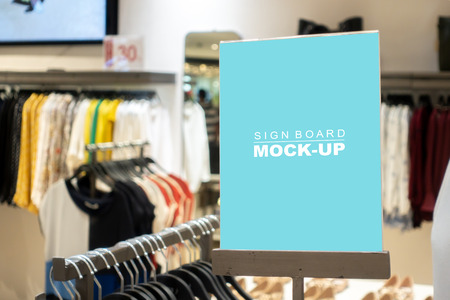 Mock up vertical blank banner or signboard with clipping path to show promotion or discount in shop clothing, Blue screen empty space for insert text or advertising in shop clothingの写真素材