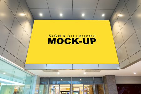 Mock up large billboard with clipping path on the wall over the entrance shopping mall, perspective yellow screen empty space to insert advertisementの写真素材