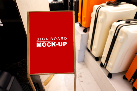 Mock up perspective the vertical blank signboard standing   at luggage shop, red screen empty space for insert text discount or advertising or announcementの写真素材