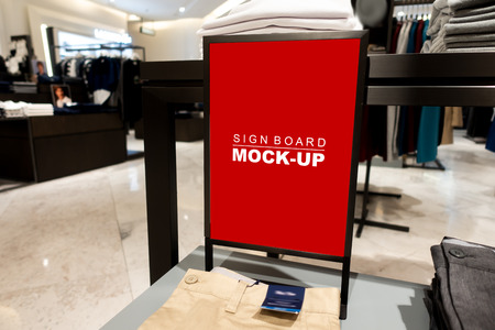 Mock up vertical blank banner or signboard hanging   on men's pants folded and stacked on showcased,  empty space for insert text or advertising in shopping mallの写真素材