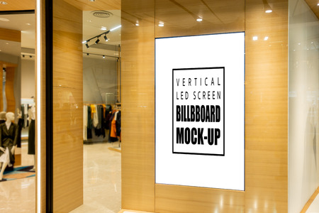 Mock up blank vertical LED screen advertising   at the entrance of fashion shop, empty space to insert media advertisementの写真素材