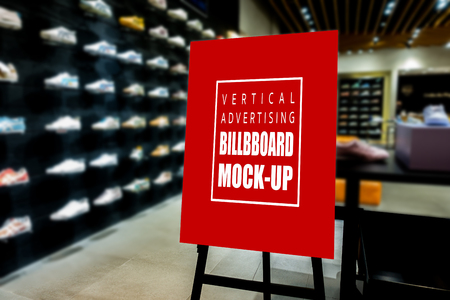 Mock up perspective of vertical advertising billboard   on wooden stand in showroom of sport shoe, red screen empty space for insert text and priceの写真素材