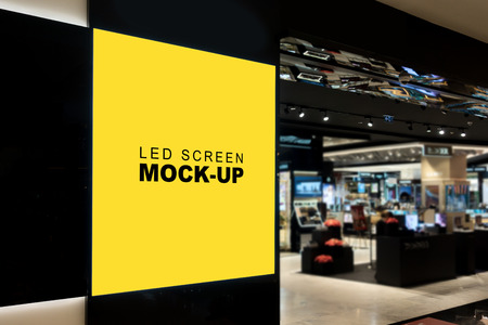 Mock up blank LED billboard for advertising on black backdrop , yellow empty space for multi media or information for promotion at front of IT shop in mallの写真素材