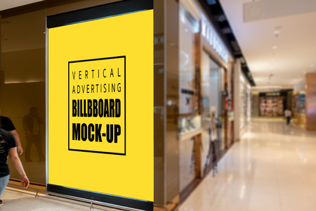 Mock up vertical blank billboard , Advertising signage for promotion on the wall at aisle inside the department store, yellow screen empty space for insert text or mediaの写真素材