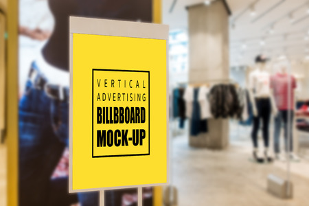 Mock up perspective vertical advertising blank yellow screen billboard   for insert text message content at front of fashion clothing store, marketing and advertisement conceptの写真素材