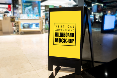 Mock up vertical blank billboard stand to show promotion or discount, tall yellow screen empty space for insert text or advertising in shopping mallの写真素材
