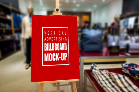 Mock up vertical blank advertising board   on drawing frame stand, decoration design in fashion shop, empty space for insert text promotion and priceの写真素材