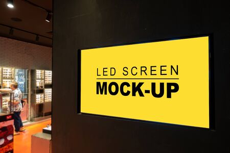 Mock up perspective blank horizontal advertising LED billboard at pole of eyeglass shop  in shopping...