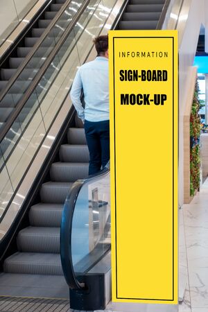 Mock up vertical blank billboard or signboard roll up near escalator, Empty space for advertising or informationの写真素材