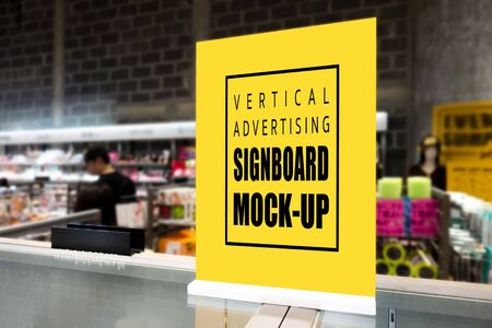 Mock up perspective blank vertical signboard   standing on glass counter in supermarket, empty space for insert advertising, information, price and promotionの写真素材
