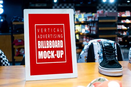 Mock up perspective vertical blank billboard on showcase of sport shoes  in frame, Empty signboard for information price or promotion advertising, blurred people in backgroundの写真素材