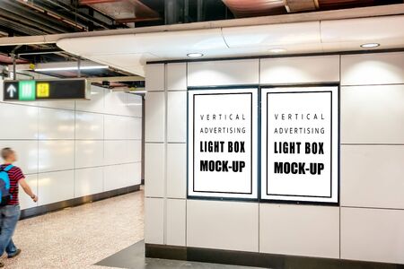 Mock up two blank vertical light box with   placed near entrance and walkway in metro station, blurred , empty  for advertising or information, advertising conceptの写真素材