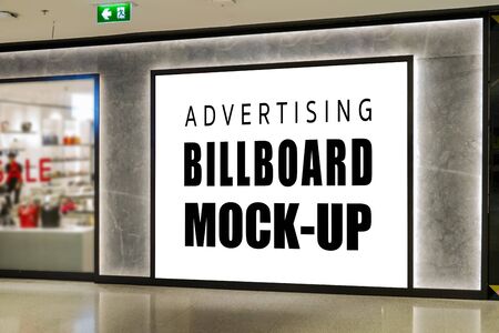 Mock up front view with large blank advertising billboard   on the wall of shop, light on backdrop, empty space for insert advertisement or promotion informationの写真素材