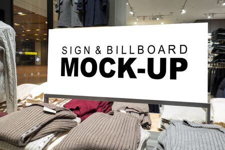 Mock up horizontal signboard with clipping path at shelf show winter cloths, blank space for insert advertising or information indoor billboard in clothing storeの写真素材