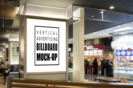 Mock up perspective blank vertical signboard with clipping path on the pole at food court in shopping mall, empty space for insert advertising or announcement informationの写真素材